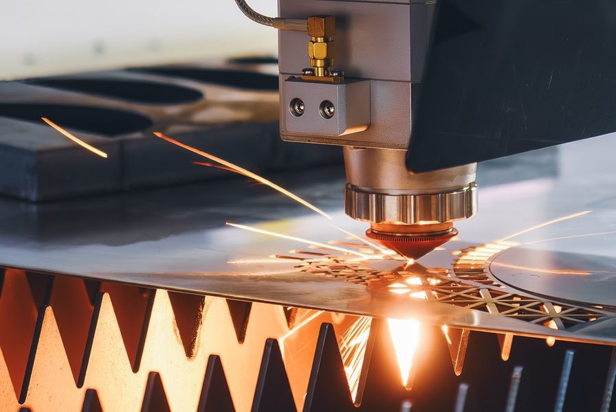 CNC_Lasern CNC-Laser Schneidvorgang mit Funken auf Metalloberfläche.